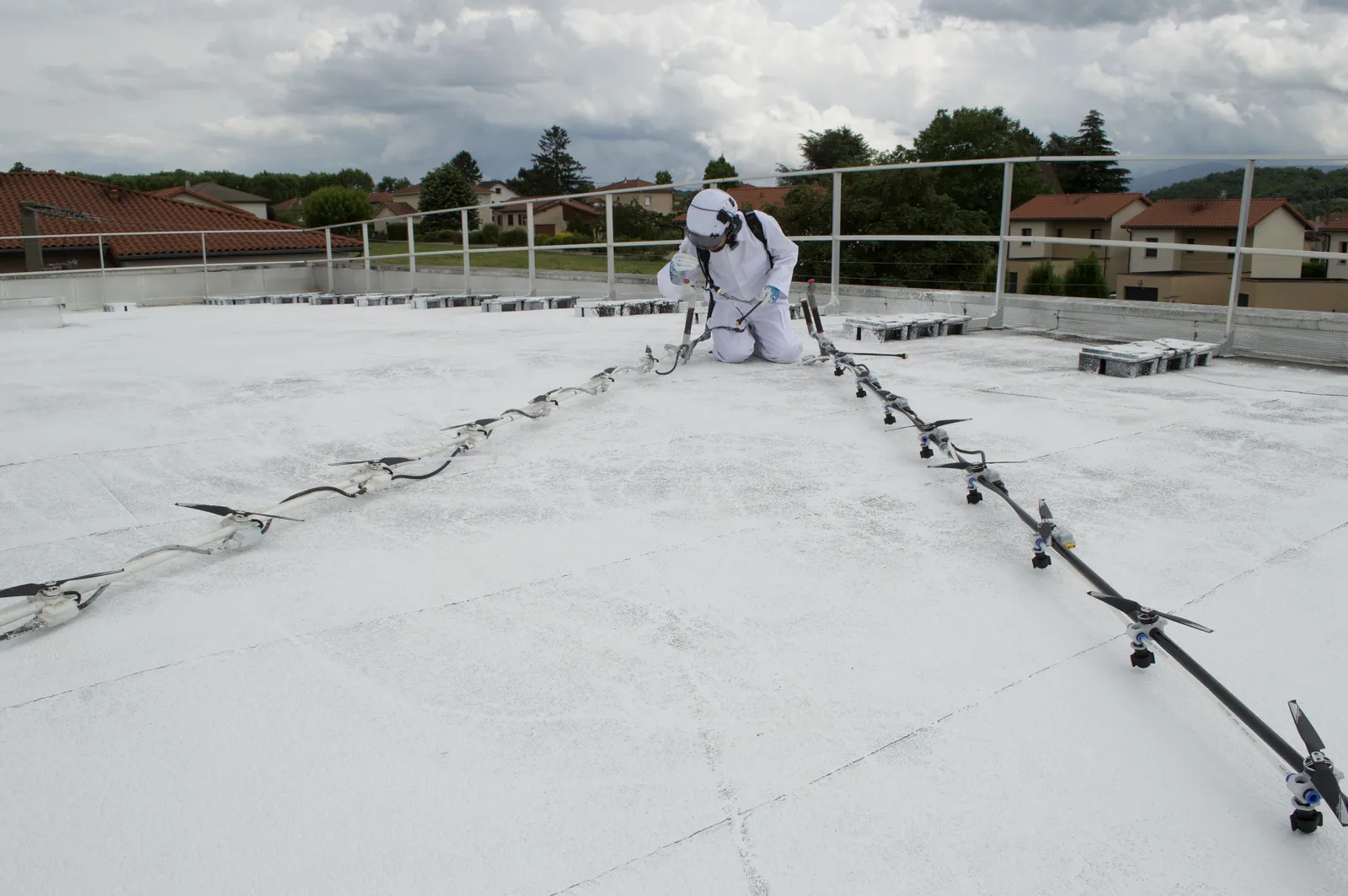 Rampe EasyBreeze déployée sur une toiture-terrasse blanchie, l'opérateur au fond
